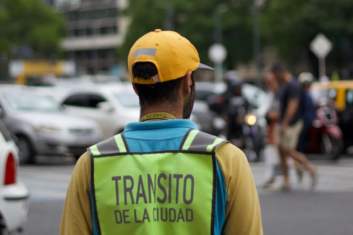 Agente del cuerpo de tránsito de la Ciudad de Buenos Aires controlando la circulación en una avenida — Bajar la deuda de multas