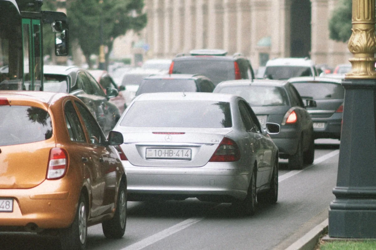 Fila de autos con las patentes a la vista: el dominio con el que se consulta el libre deuda de infracciones — consulta por dominio